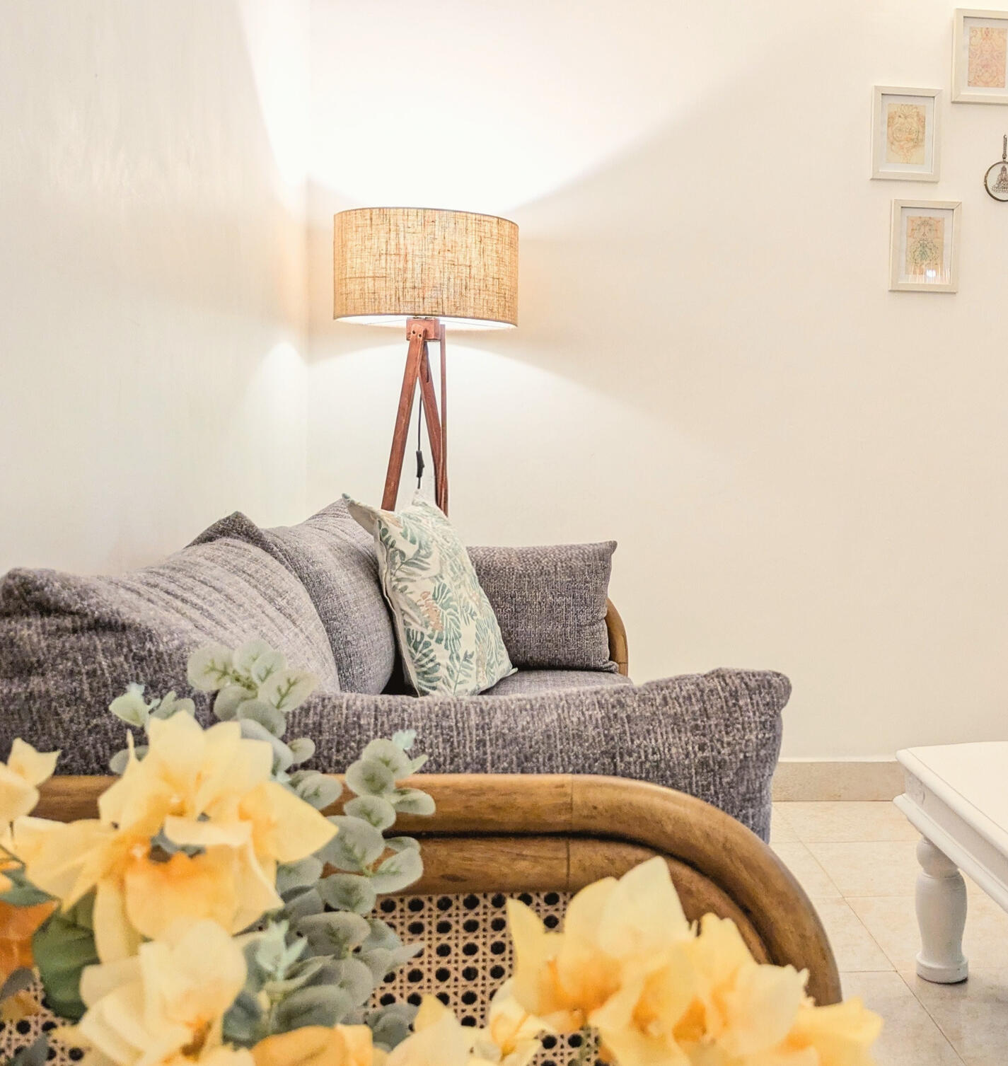 Click here for Papaya apartment Living room with gray sofa, floor lamp, white coffee table, wall art, and woven stool in a bright, minimalist space.